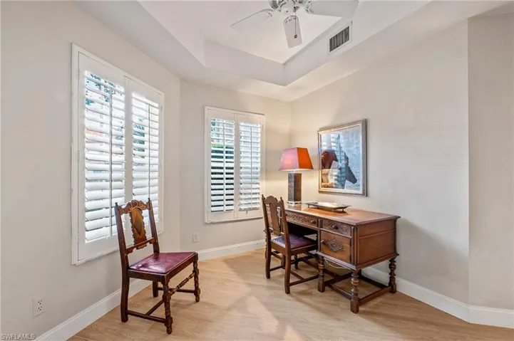 3rd Guest Bedroom/Home office featuring light hardwood / wood-style floors, ceiling fan, and a raised ceiling