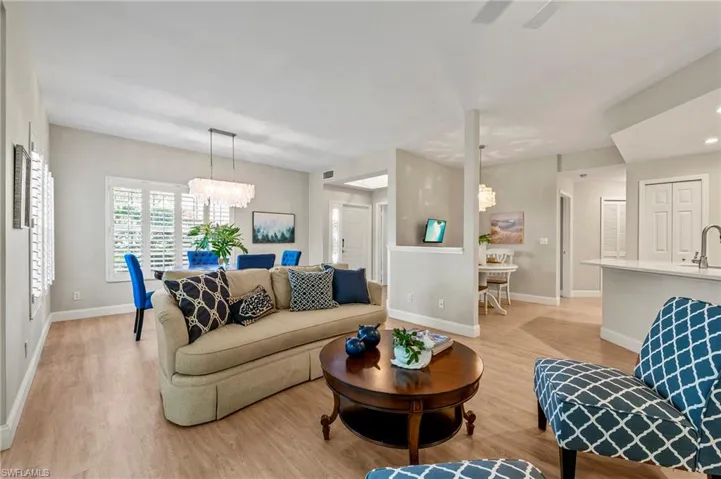 Living room featuring light hardwood / wood-style floors, sink, and a chandelier