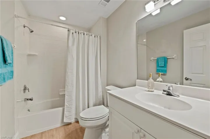 2nd Guest Full bathroom with vanity, shower / bath combo with shower curtain, toilet, and hardwood / wood-style floors