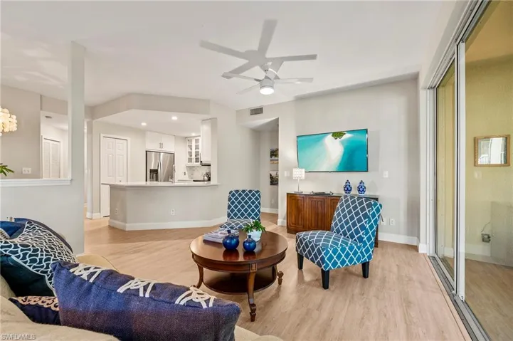 Living room with ceiling fan and light hardwood / wood-style floors