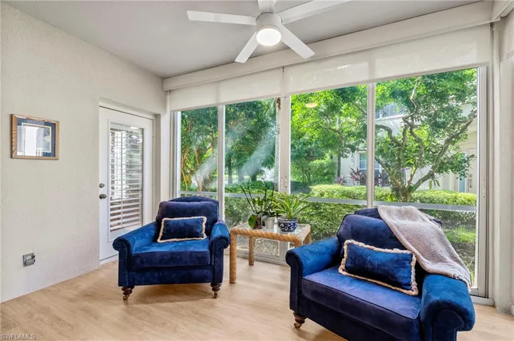 Living area with light hardwood / wood-style flooring, a healthy amount of sunlight, and ceiling fan