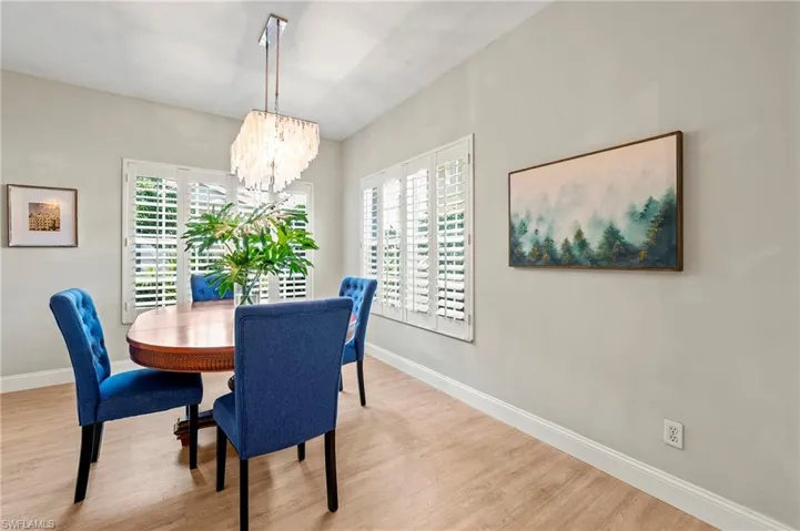 Dining space featuring a wealth of natural light, a notable chandelier, and light hardwood / wood-style floors