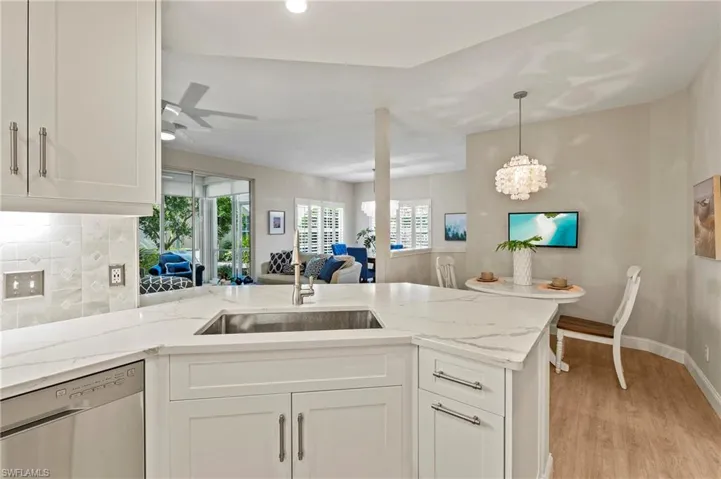 Kitchen featuring white cabinets, dishwasher, sink, and light wood-type flooring