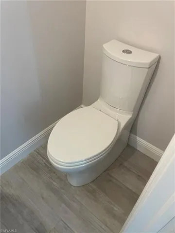 Bathroom with hardwood / wood-style floors and toilet