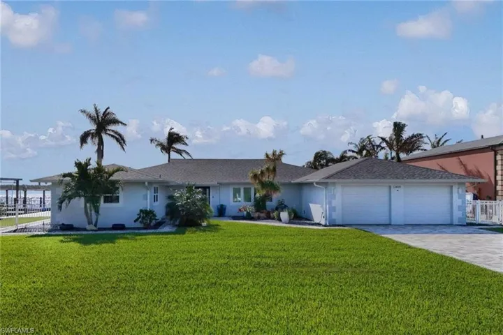 Single story home with a garage and a front lawn