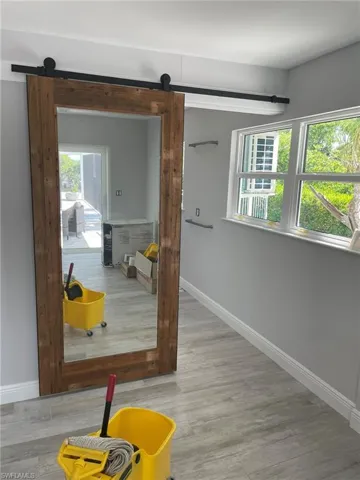 Hall with a barn door and light hardwood / wood-style floors