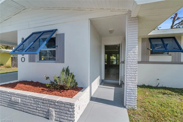View of covered entrance to home, partially screened entry