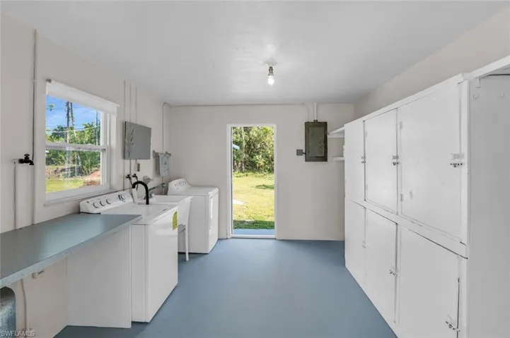 Large Utility Room with Washer, Dryer, Cabinets, Water Heater, Utility sink, Two entrances.