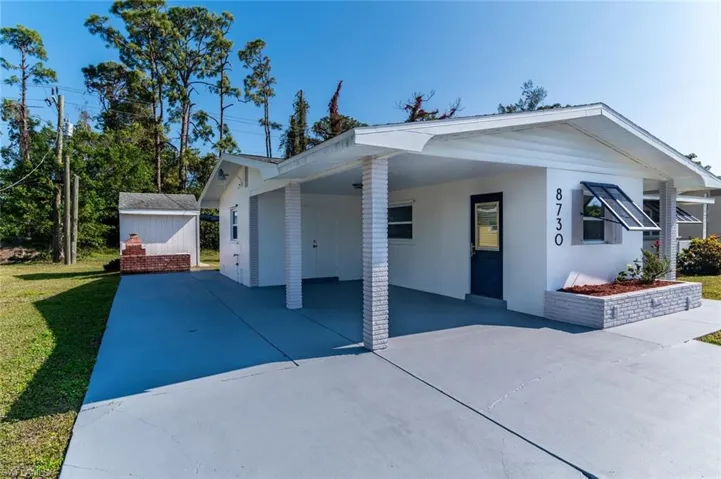 North side of house, view of carport with entry to kitchen, Utility Room, BBQ pit, Shed