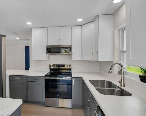 Kitchen with undermounted sink, white and gray cabinetry, stainless steel appliances