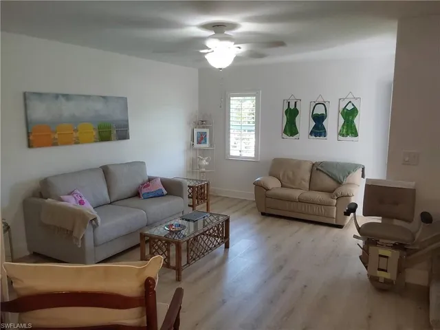 Living room with ceiling fan and l