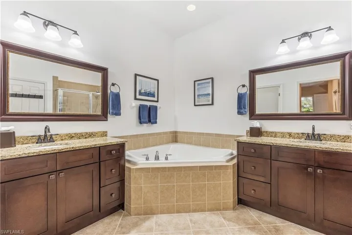 Dual sinks and vanities and oversized tub.   Shower is there too.