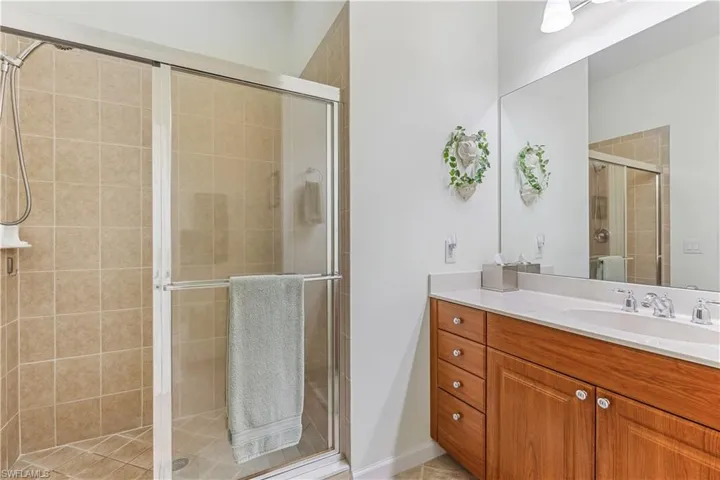 Full bath featuring vanity, a stall shower, and light tile patterned floors
