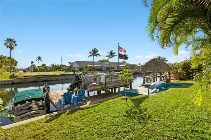 View of dock with a yard and a water view