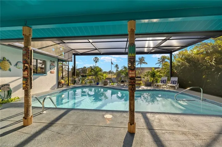 Pool featuring glass enclosure and a patio