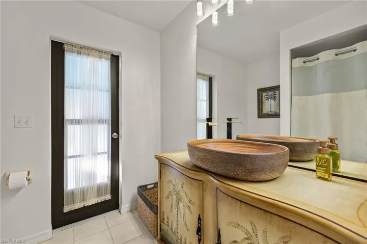 Full bath featuring baseboards, vanity, and tile patterned flooring
