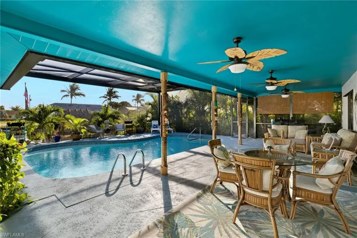 View of pool with glass enclosure and a patio
