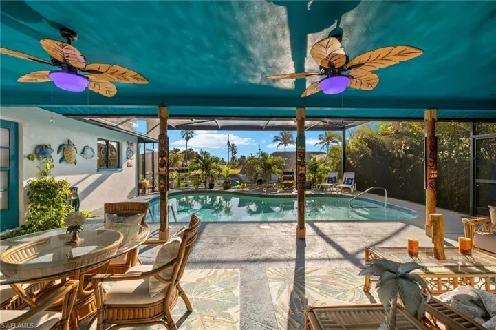 Outdoor pool featuring ceiling fan, a patio, and a lanai