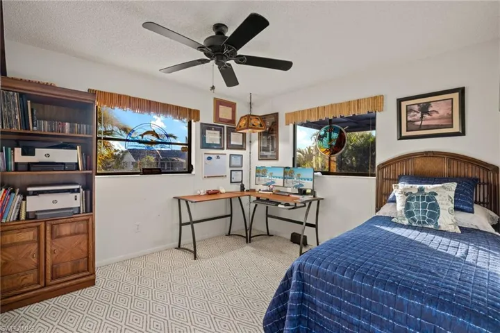 Bedroom with a textured ceiling and ceiling fan