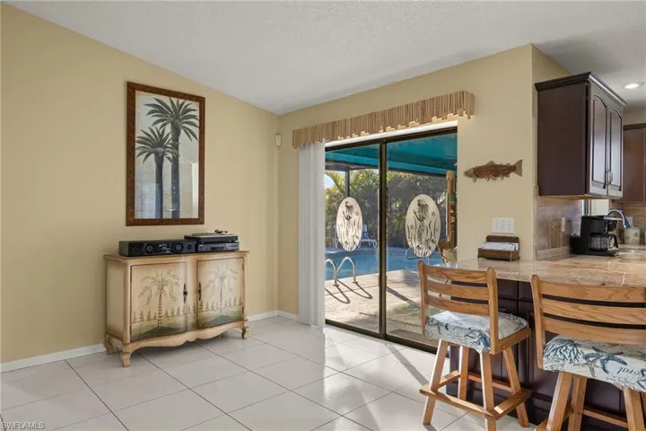 Doorway with light tile patterned floors, a textured ceiling, and vaulted ceiling