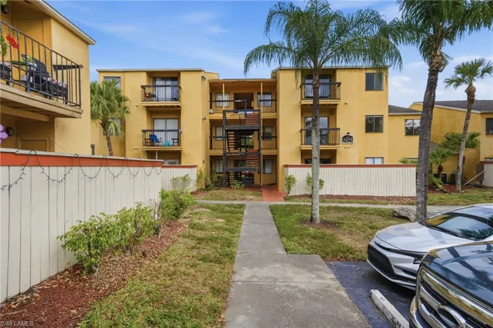 View of apartment building / complex with uncovered parking