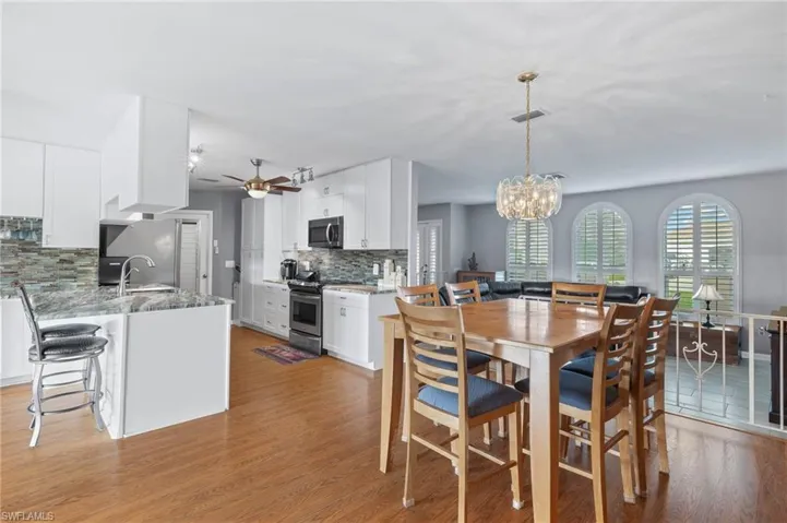 Dining space featuring light wood-style flooring, a chandelier, and ceiling fan