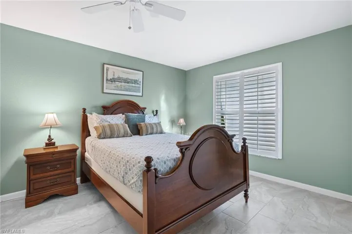 Bedroom with light marble finish flooring and a ceiling fan