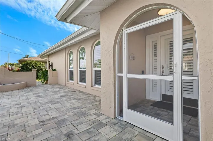 Property entrance featuring stucco siding and a patio