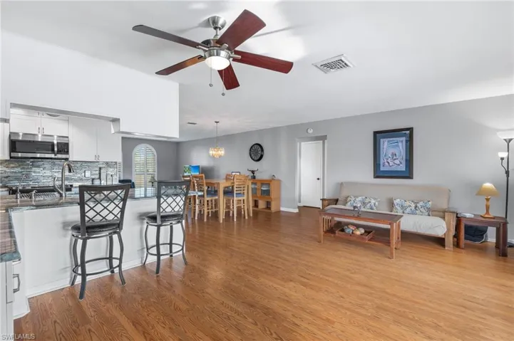 Living area with light wood-type flooring and a ceiling fan