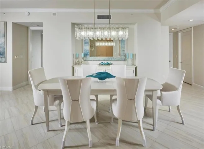 Dining area with ornamental molding, light tile patterned flooring, a chandelier, and recessed lighting