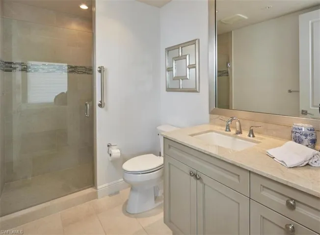 Bathroom featuring vanity, a stall shower, and light tile patterned floors