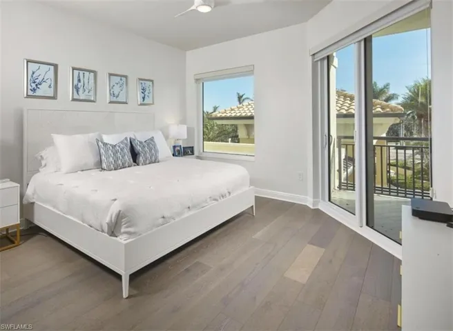 Bedroom featuring access to exterior, wood finished floors, and ceiling fan