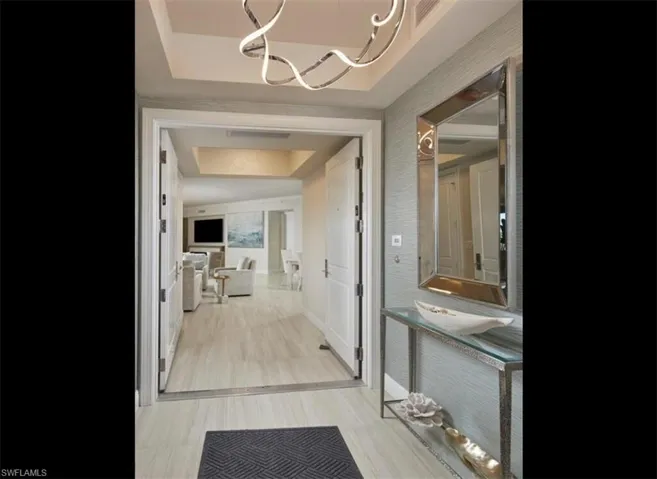 Bathroom with a chandelier and a raised ceiling