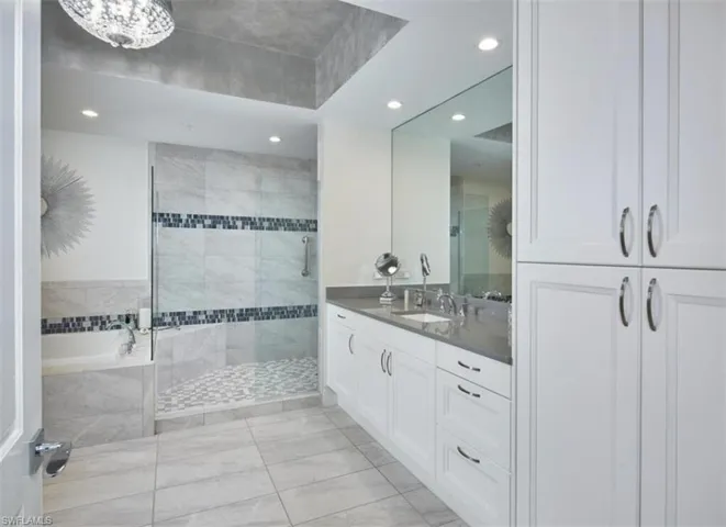 Full bath featuring vanity, a walk in shower, recessed lighting, light tile patterned floors, and a garden tub