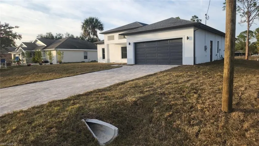 View of front of home with a garage and a front lawn