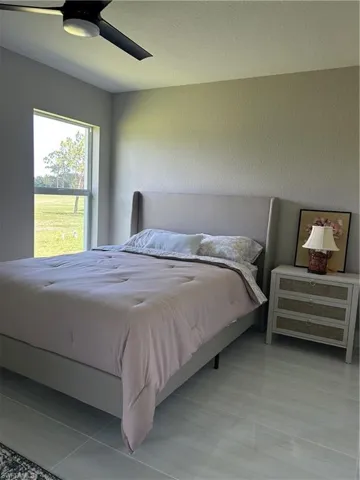 Room featuring a large window, light-toned walls, and tile flooring