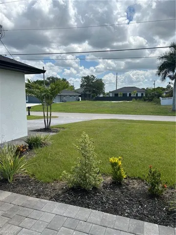 Manicured lawn with a paver pathway and mature landscaping