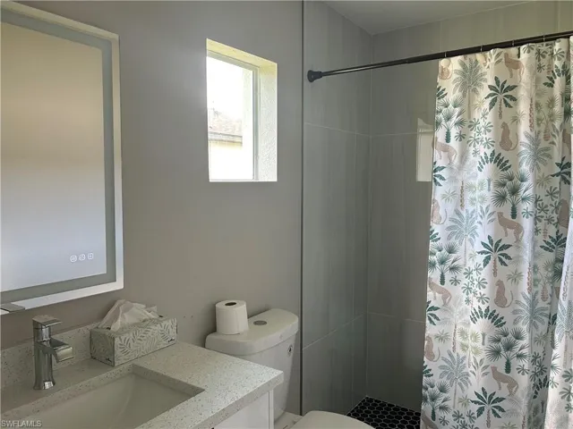 Bathroom featuring a vanity with an integrated rectangular sink, speckled countertop, and modern faucet