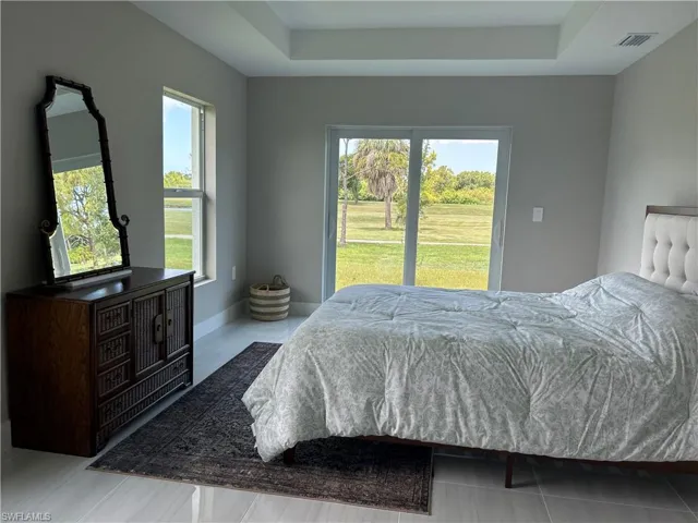 Bedroom featuring light gray walls and large format tile flooring
