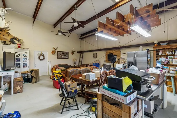 Garage featuring ceiling fan and stainless steel refrigerator with ice dispenser