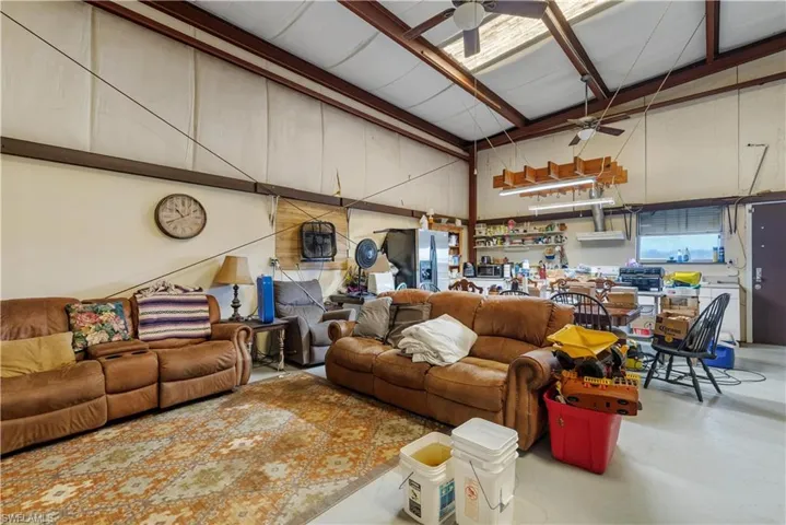 Living room featuring washer / clothes dryer, concrete flooring, a high ceiling, and ceiling fan