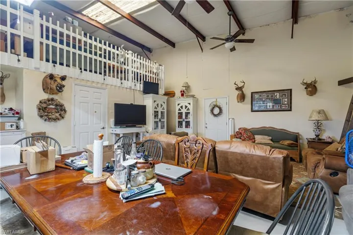 Dining space with beamed ceiling, a towering ceiling, and ceiling fan
