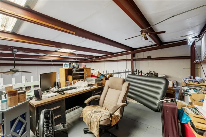 Office area featuring a workshop area, ceiling fan, and vaulted ceiling with beams