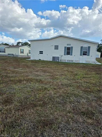 Rear view of house featuring a yard