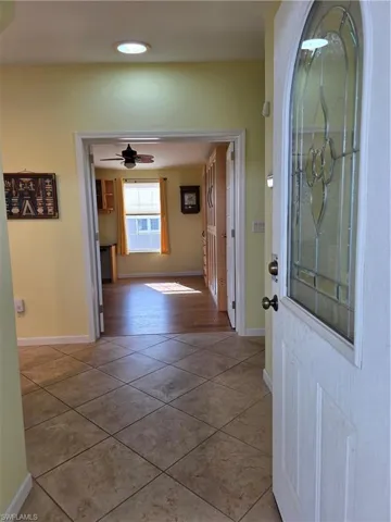 Hall with baseboards and light tile patterned floors