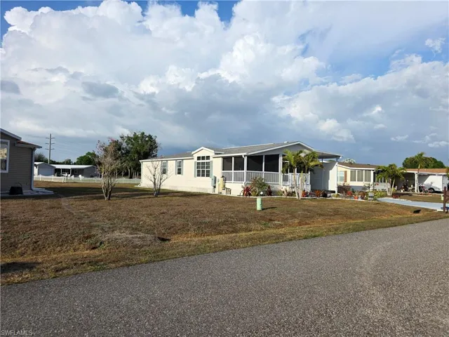 Manufactured / mobile home featuring a sunroom and a front yard