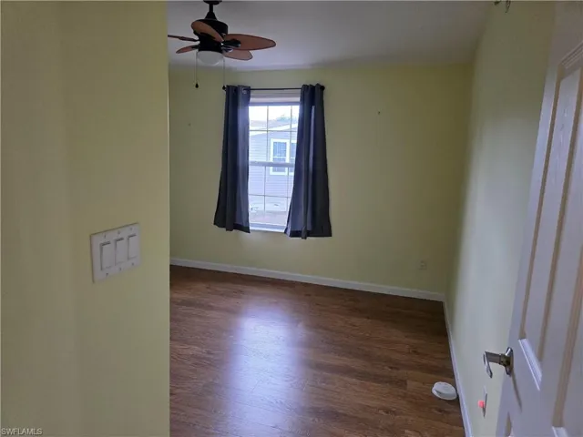 Spare room featuring dark wood-style floors and a ceiling fan