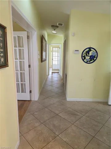 Hallway with light tile patterned floors and baseboards