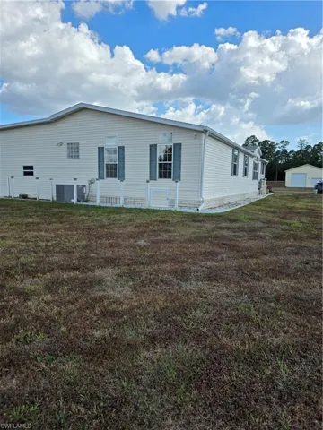 Rear view of house with a yard, an outdoor