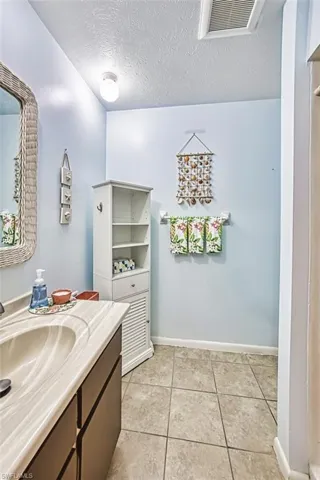 Bathroom featuring vanity, a textured ceiling, and tile patterned flooring